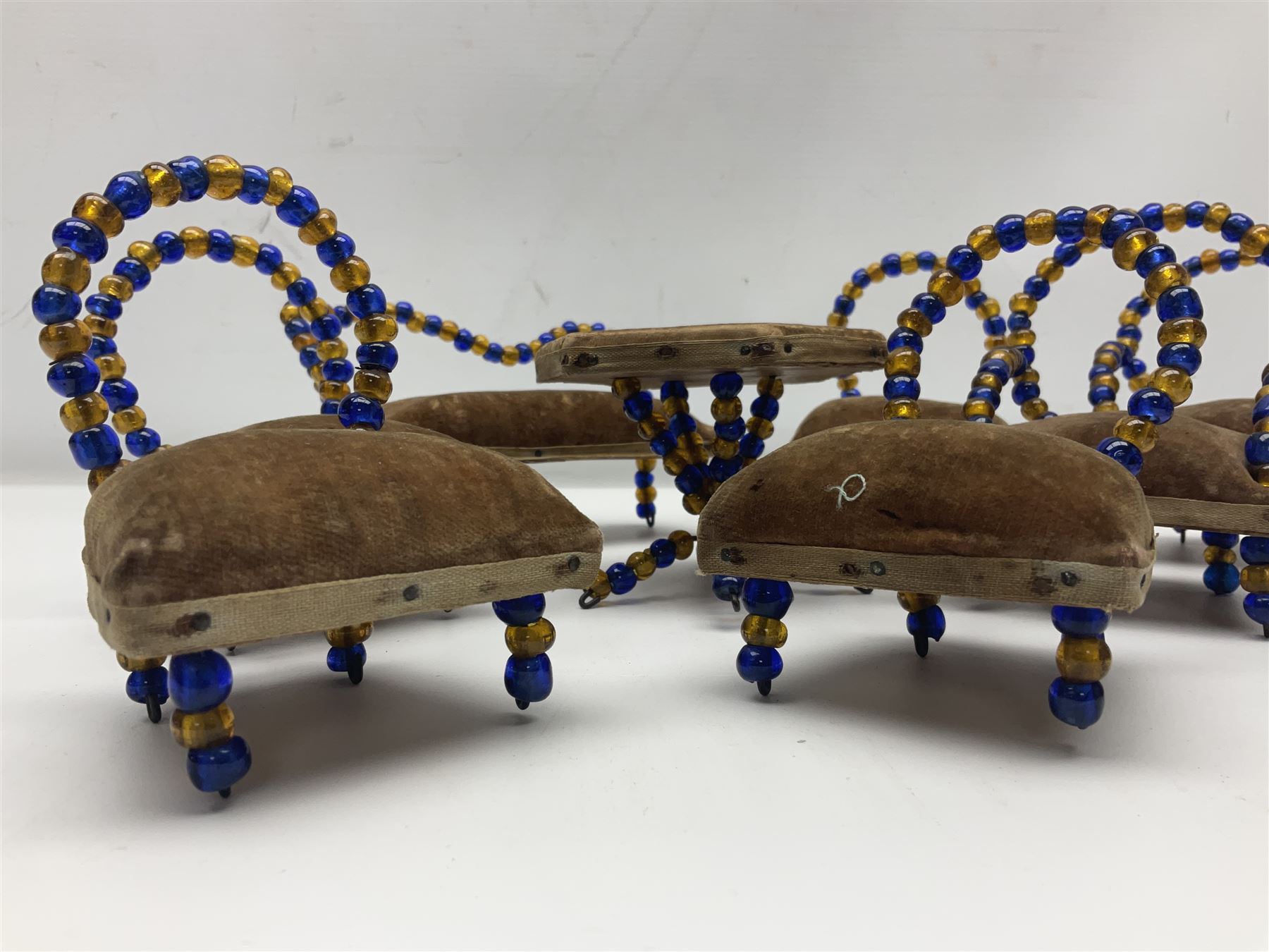 Quantity of early 20th century doll's house furniture comprising Victorian style beadwork and upholstered eight-piece salon suite; beadwork dining table with four matching chairs; and Kleeware brown plastic seven-piece dining suite