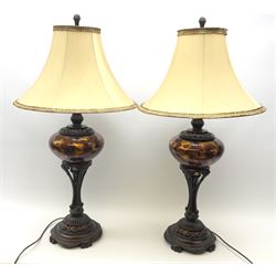Two large bronzed composite table lamps, with central marbled tortoiseshell effect bodies supported upon foliate detailed stems and spreading bases, with fabric shades, overall H96cm. 