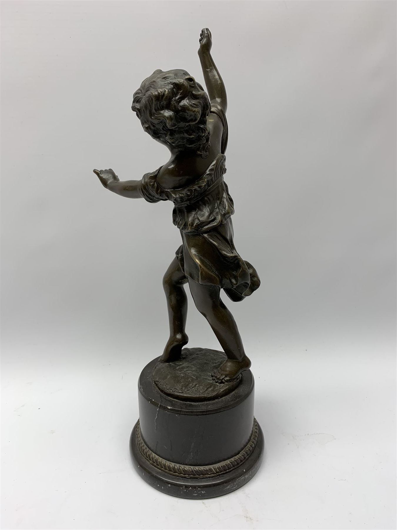 After E Plat, bronze modelled as a dancing child, signed E. Plat, upon cylindrical black marble base, H40cm