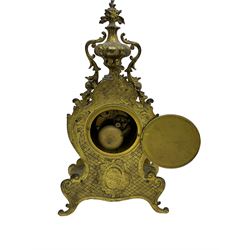 French - late 19th century 8-day gilt brass mantle clock surmounted by an urn, with a waisted case and baroque decoration raised on four splayed feet, with a glazed bezel, enamel dial with Roman numerals, five minute Arabic's and gothic steel hands, count wheel striking movement, striking the hours and half-hours on a bell. With pendulum.