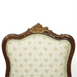 Louis XV design salon suite comprising a pair of walnut and parcel-gilt fauteuil armchairs together with a side chair, the cresting rail surmounted with a carved giltwood floral shell motif with extending foliage, the cartouche shaped backs and sprung seats upholstered in pale blue patterned fabric, over a shaped apron with scallop decoration and foliage carved knees, raised on cabriole supports