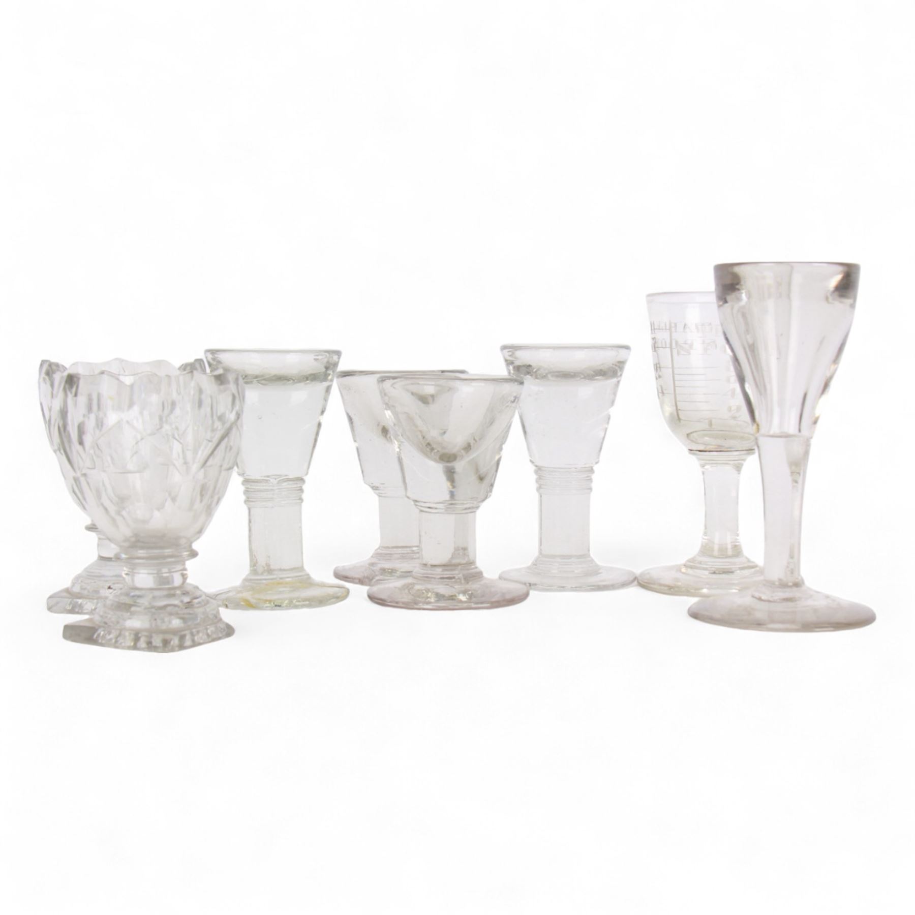 Five 19th century penny lick glasses, together with a pair of 19th century cut glass open salts with lemon squeezer bases, and a 19th century glass measure, largest example H12cm