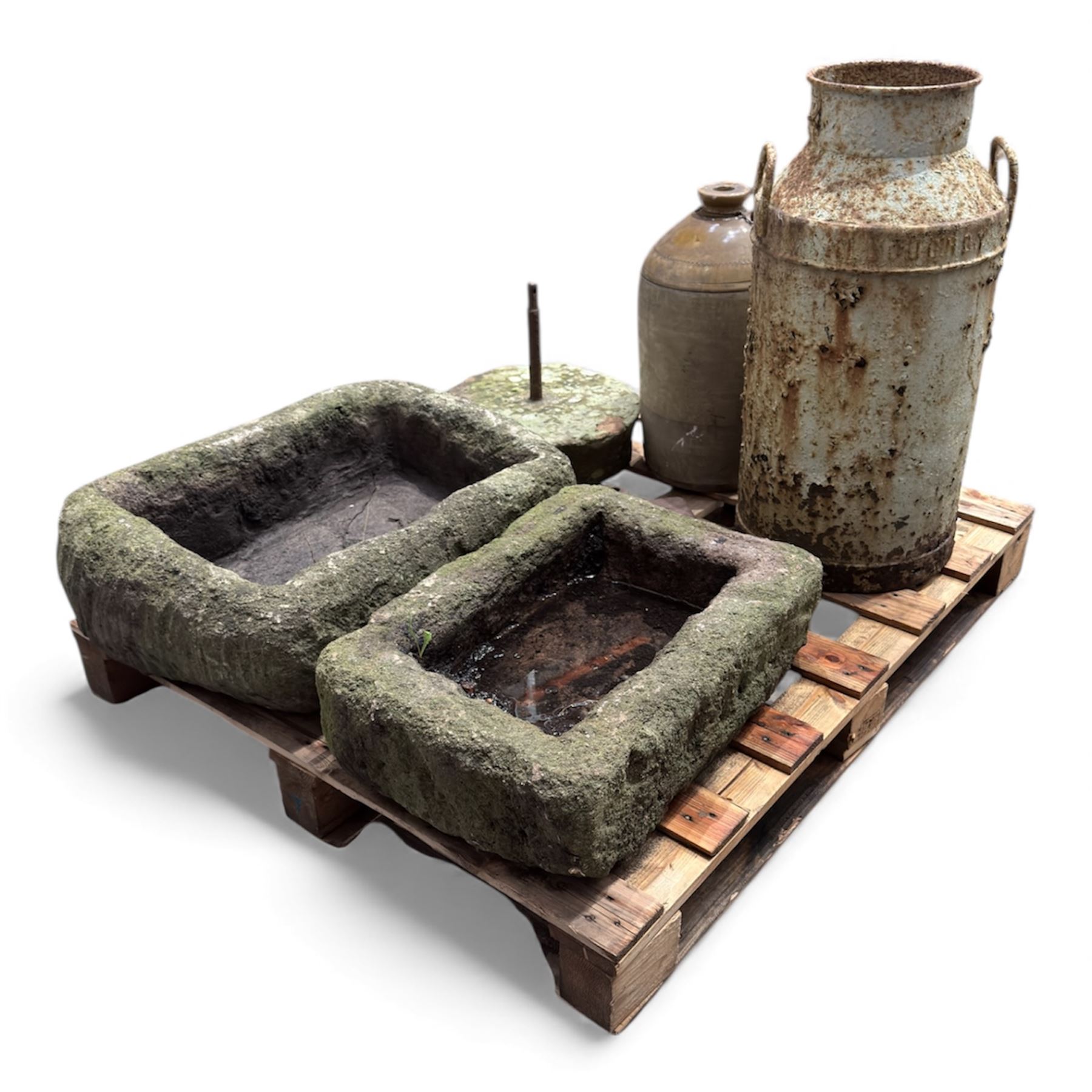 Two 19th century stone troughs, with mill stone, flagon and metal milk churn 