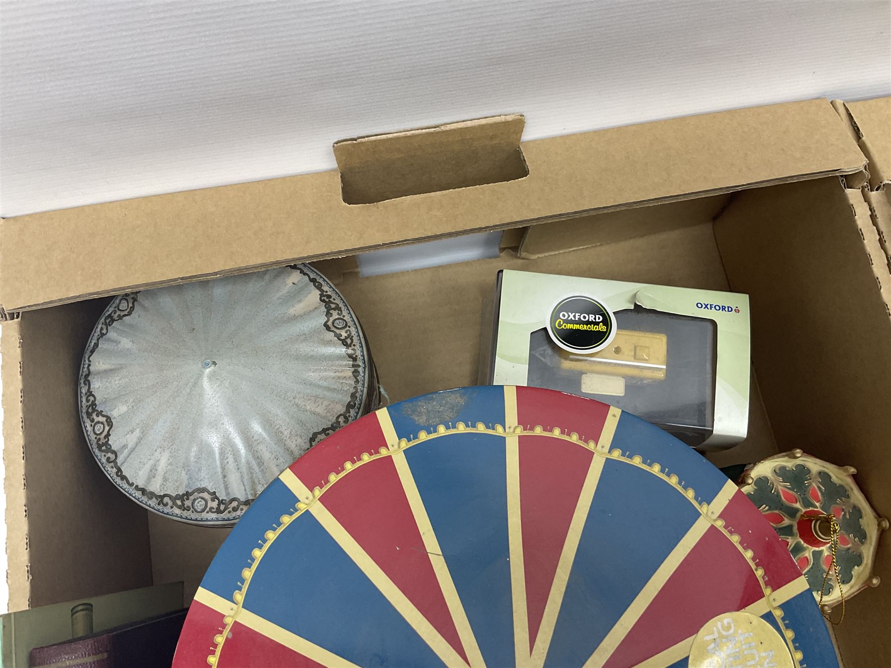 Collection of circus and fairground collectables, to include teapots, biscuit tins, including musical examples, and four Circus/fair themed books, including two library first editions