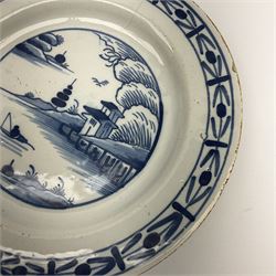 An 18th century Delft tin glazed plate, painted with waterside landscape, D24cm