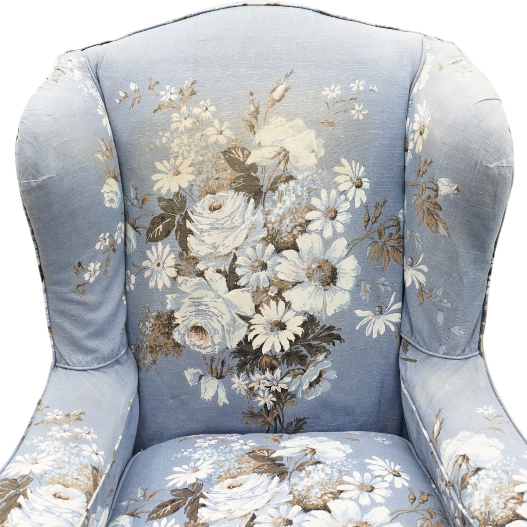 Pair of Queen Anne wingback armchairs, high back over out-swept arms, raised on ball-and-claw feet, upholstered in sky-blue ground floral chintz loose upholstery with pleated skirt and squab cushion