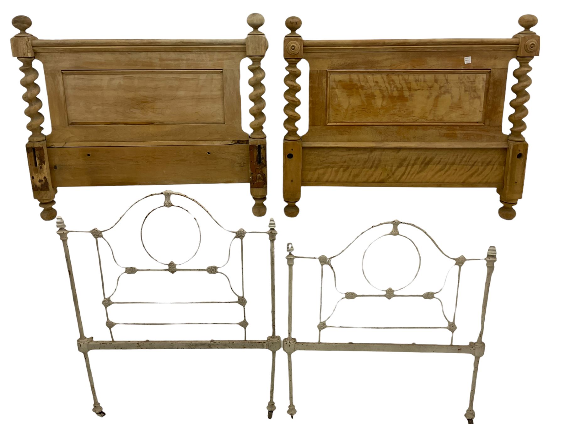 Two stripped walnut barley twist headboards, and a pair of wrought metal single bed ends