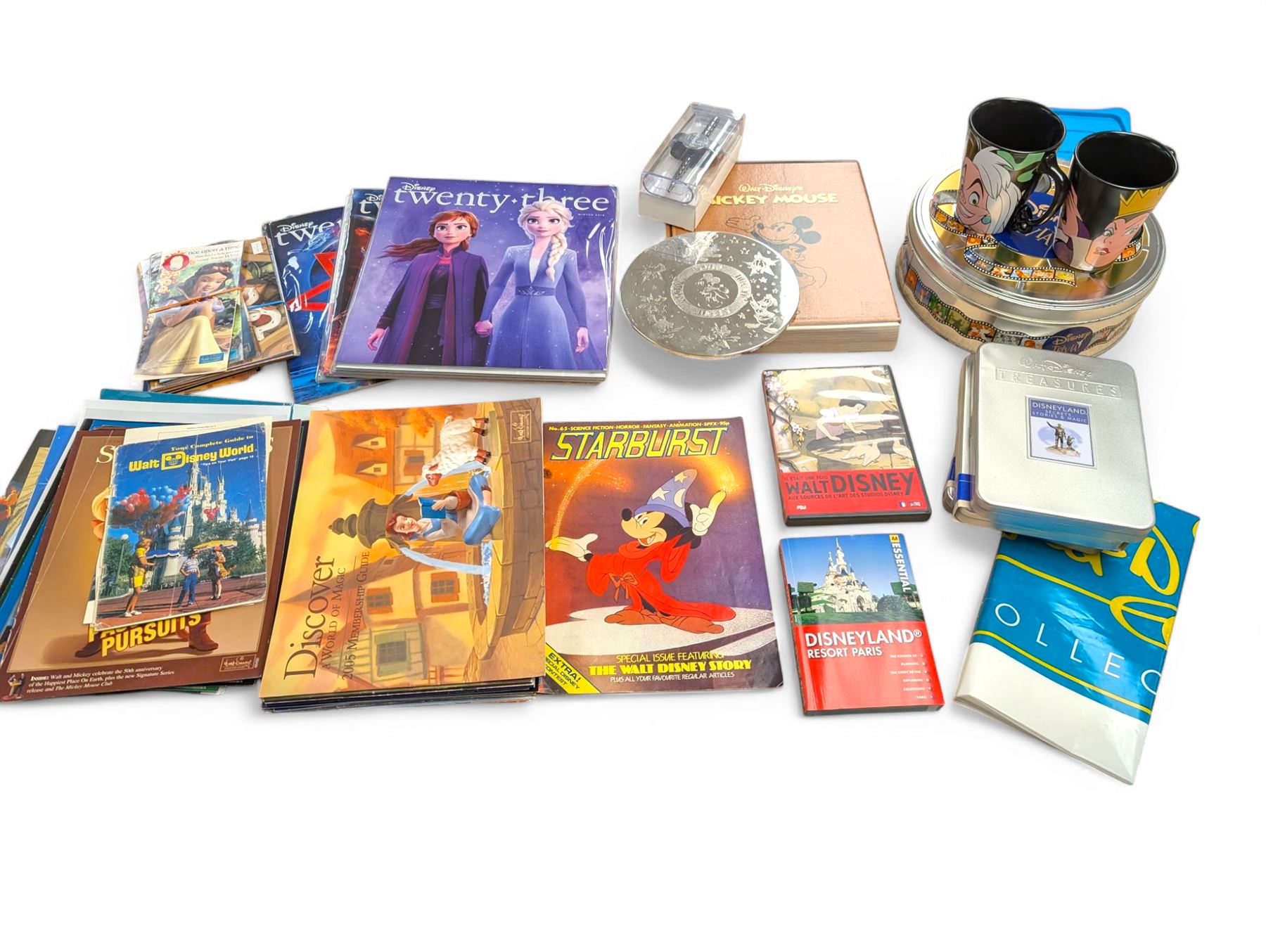 Collection of Disney memorabilia and ephemera, including Walt Disney Treasures DVD, two Disney Villains mugs, enamel pins, Mickey Mouse D23 fan club pack, Disney Twenty-Three magazines, Sketches magazines, etc
