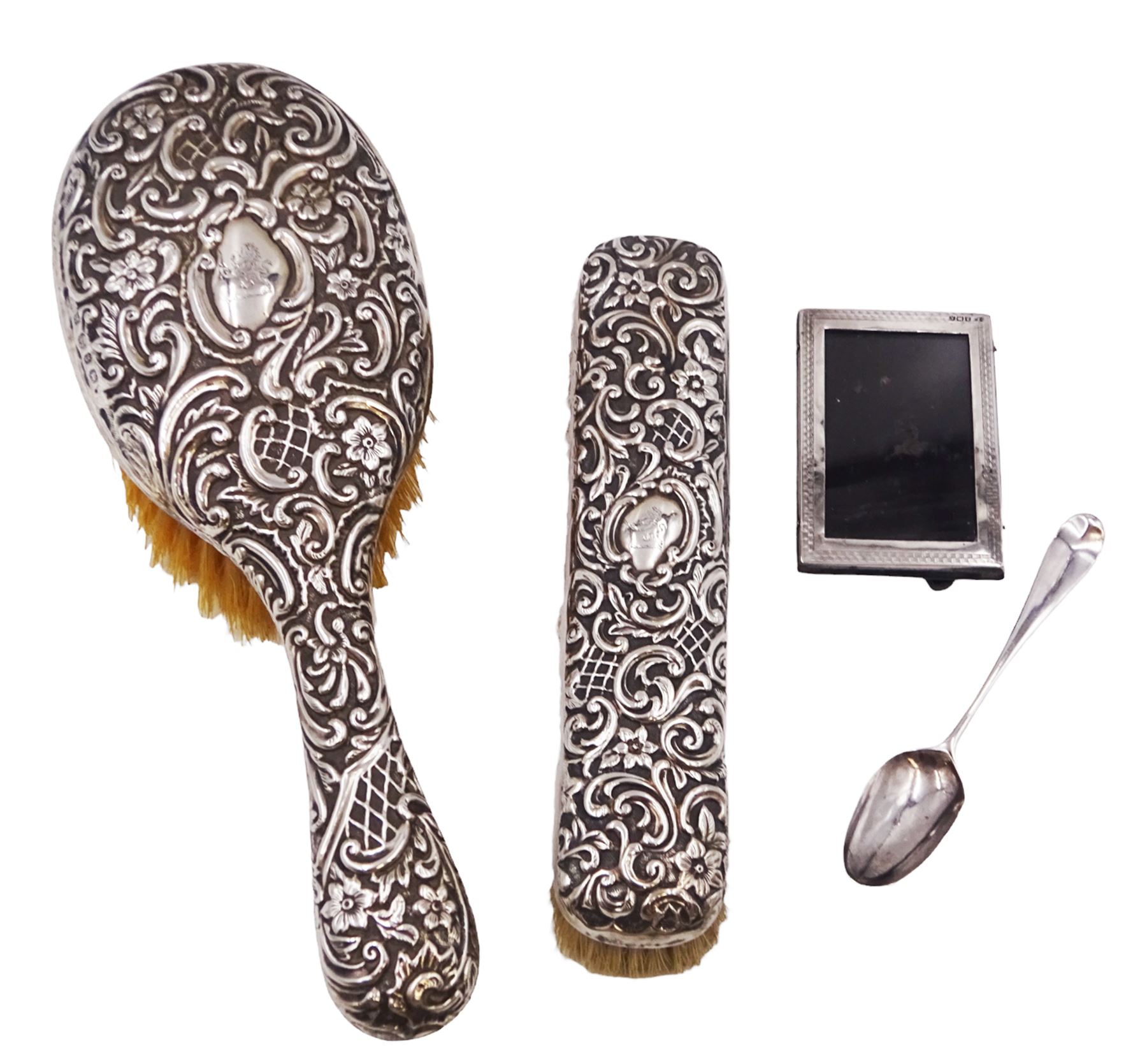 Group of silver, comprising Victorian silver hair brush and matching clothes brush, with repousse floral and scroll decoration, and each engraved with lion rampant to central cartouche, hallmarked Henry Matthews, Birmingham 1895, together with a 1920s miniature silver mounted photograph frame, hallmarked Charles Edwin Turner, Birmingham 1925 H7cm, and a Georgian silver Hanoverian pattern teaspoon, with scroll decoration to underside of bowl and engraved initials verso, hallmarks worn and indistinct