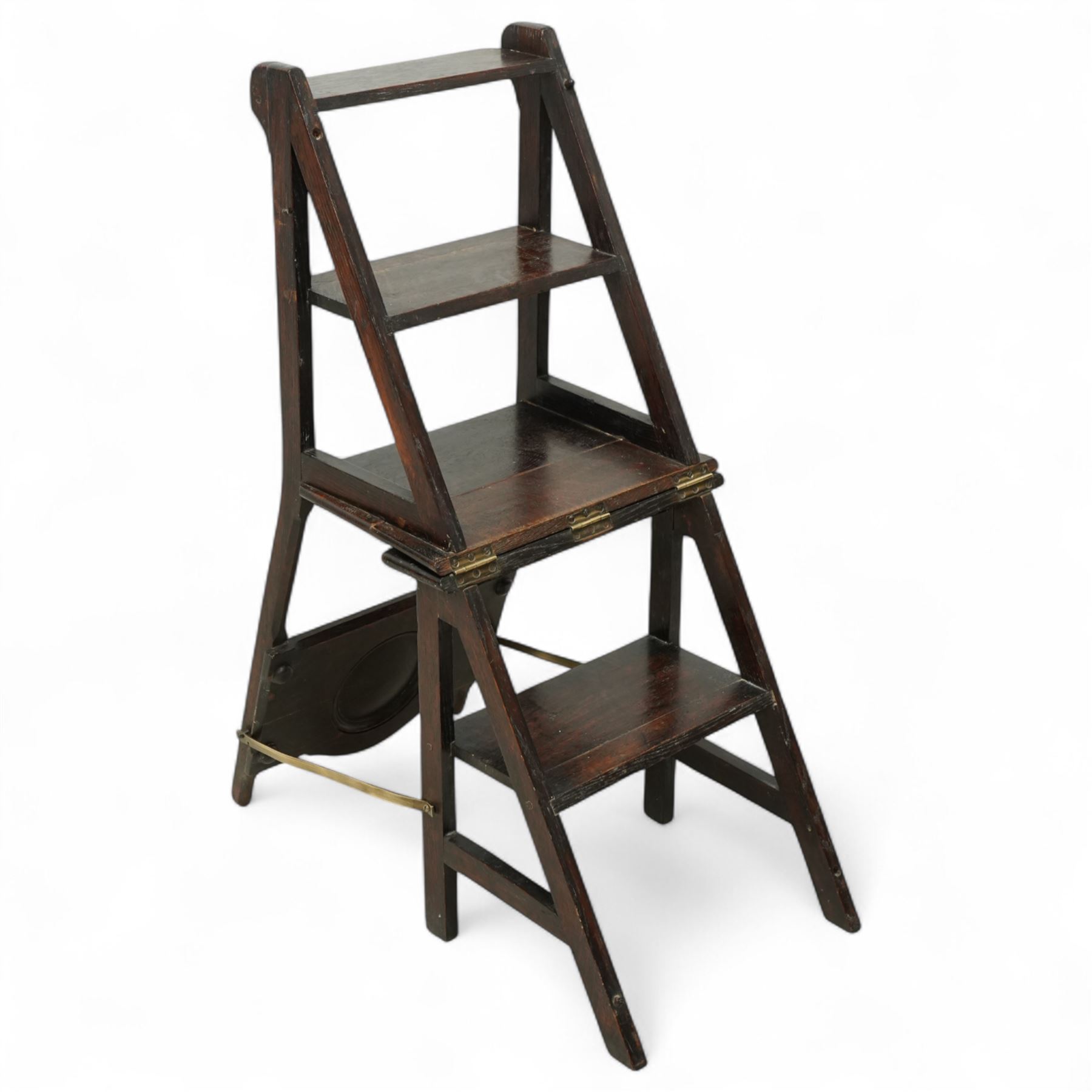 Arts & Crafts oak metamorphic chair, circular panelled back above hinged seat opening into a set of library steps with brass securing straps, circa 1900