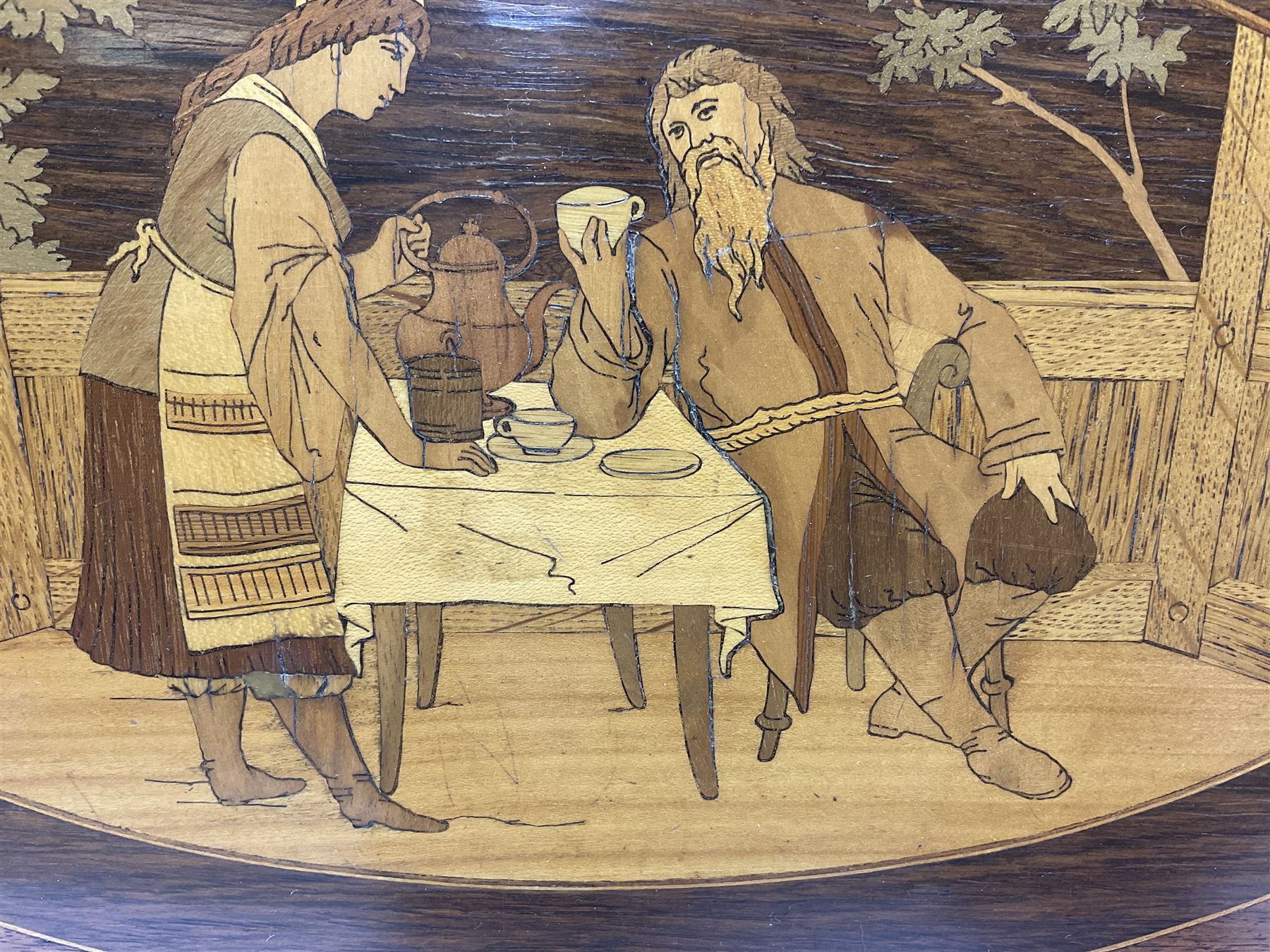 Late 19th/early 20th century mahogany and marquetry inlaid tray, of oval form with twin scrolled handles and moulded border, the central panel inlaid with figures seated at a table drinking tea, L99cm