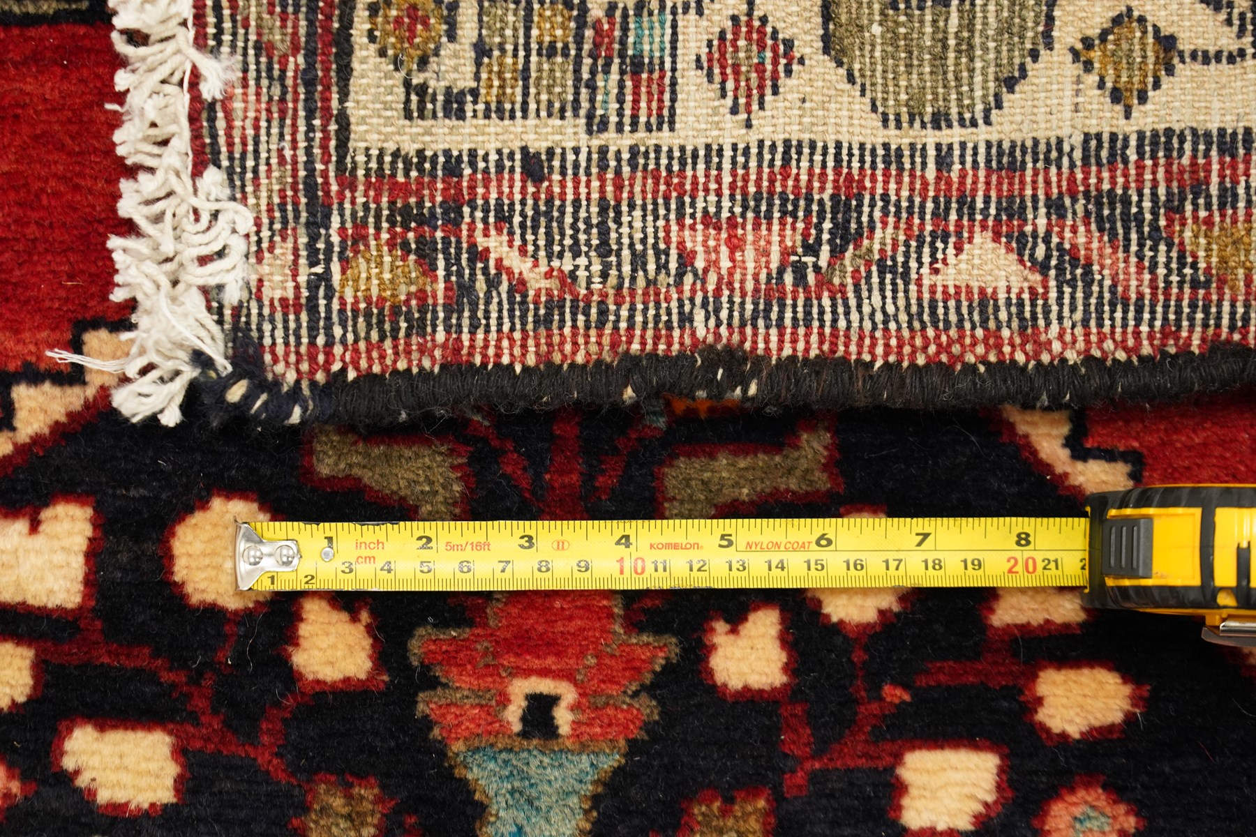 Large Persian Qashqai runner rug, the red ground decorated with navy and ivory lozenge medallions interspersed with stylised floral and geometric motifs, enclosed by an ivory flowerhead border and patterned guard stripes