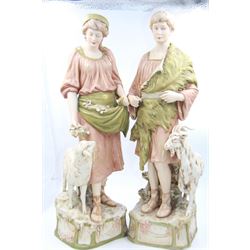 Pair of Royal Dux figures, no. 1115, modelled as a shepherd with a goat by his side and a shepherdess feeding a lamb, each wearing flowing green and pink robes with gilt detailing, with pink triangle mark beneath, H51cm