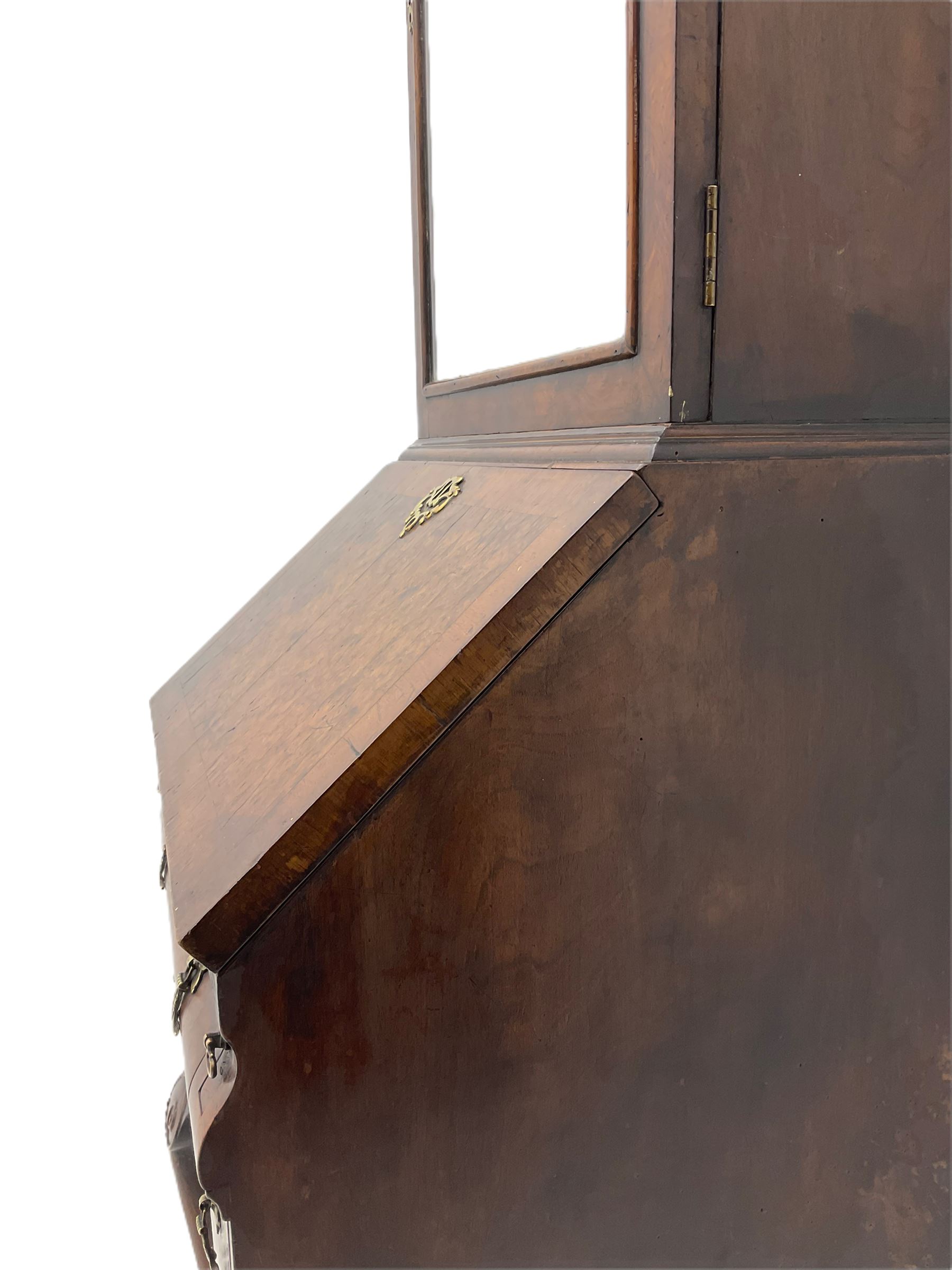 Small early 20th century Queen Anne style bookcase on bureau secretaire, the moulded arched pediment over mirrored door in shaped frame, the bureau fitted with fall front enclosing curved fitted interior, cushion moulded drawer over single drawer, on scroll and shell carved cabriole supports