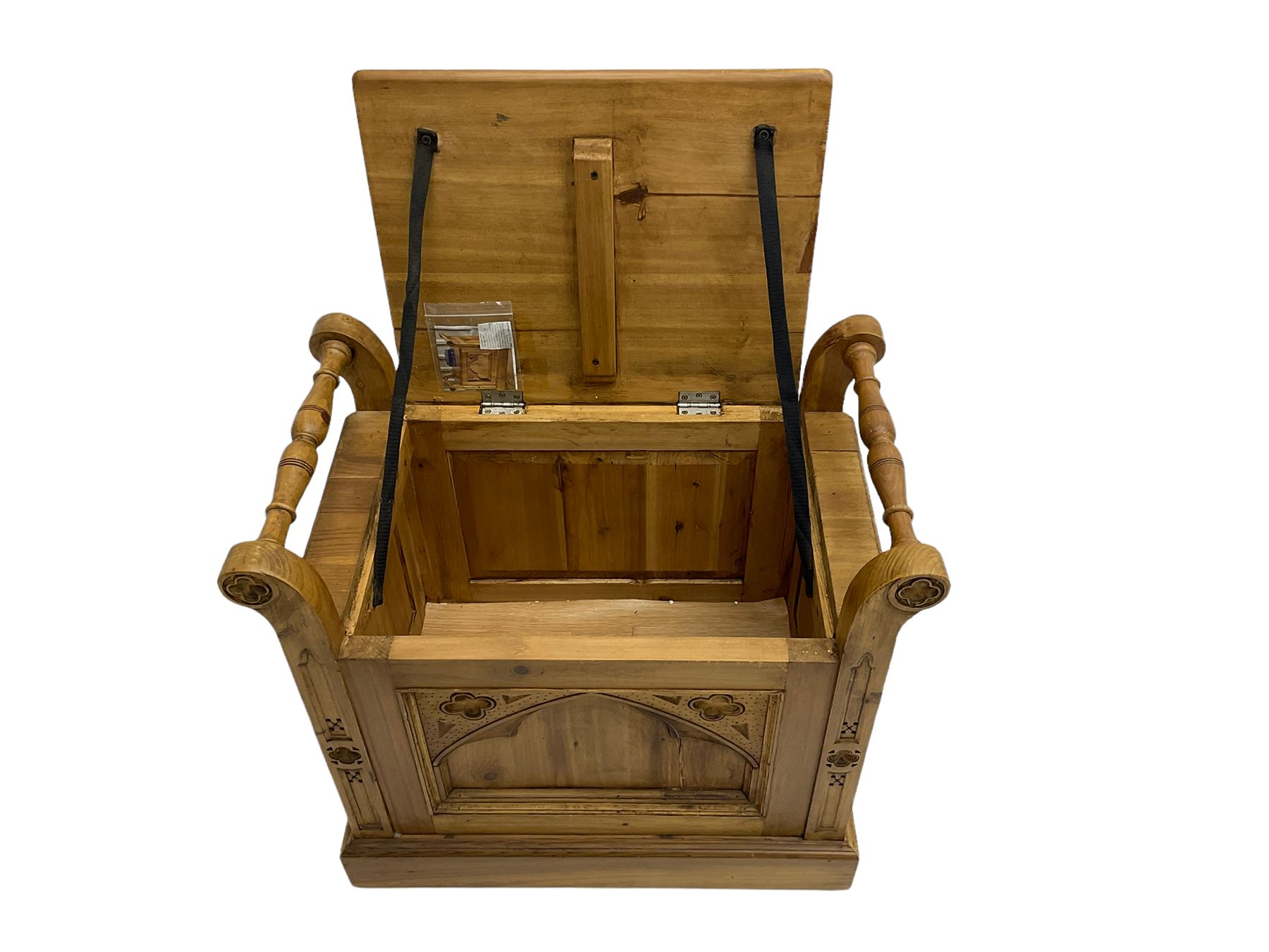 Gothic style pine stool with hinged box seat, decorated with flower head motifs, plinth base