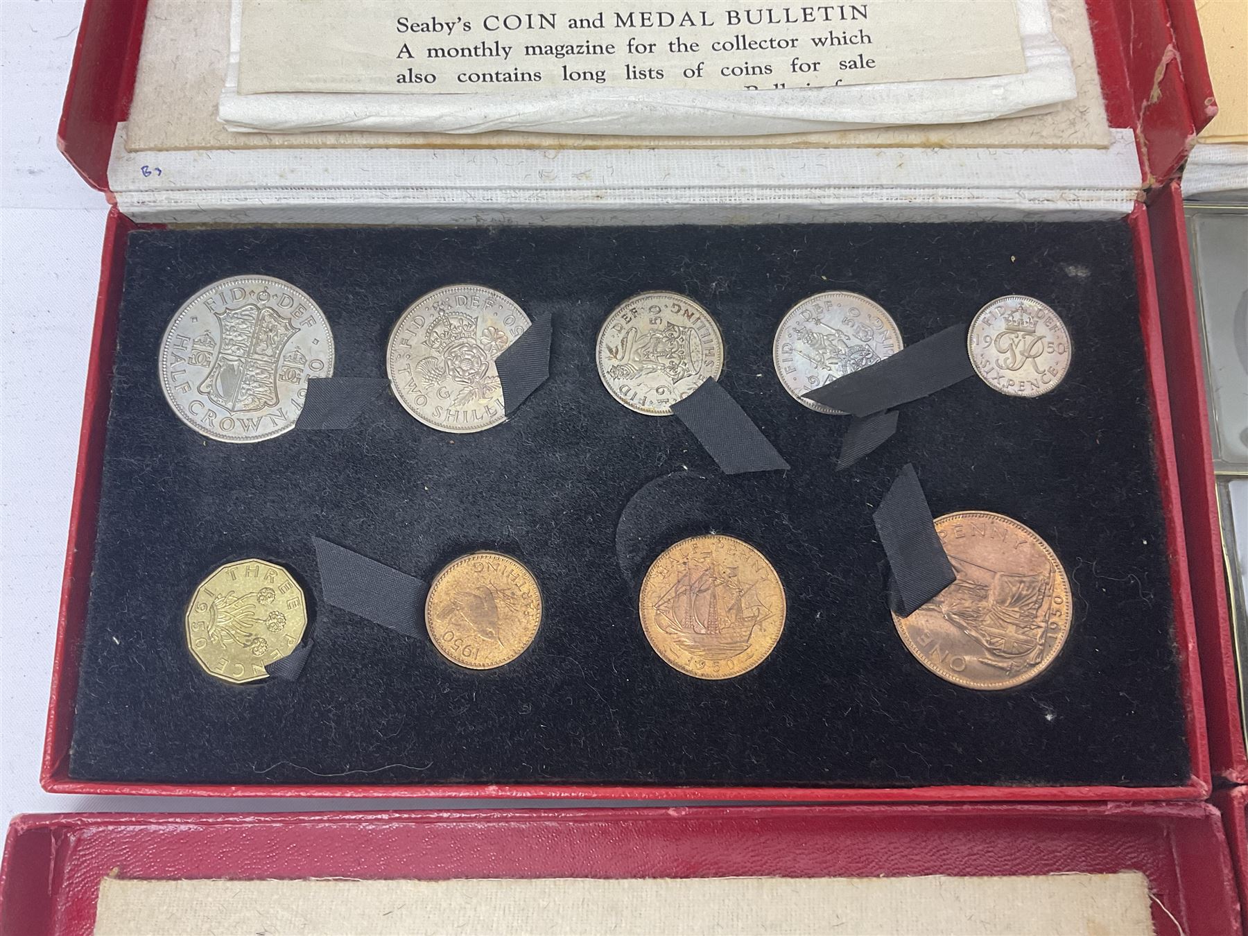 Four King George VI 1950 specimen coin sets, each comprising farthing, half penny, penny, threepence, sixpence, English  one shilling, Scottish one shilling, two shillings and half crown, each in red Royal Mint card case