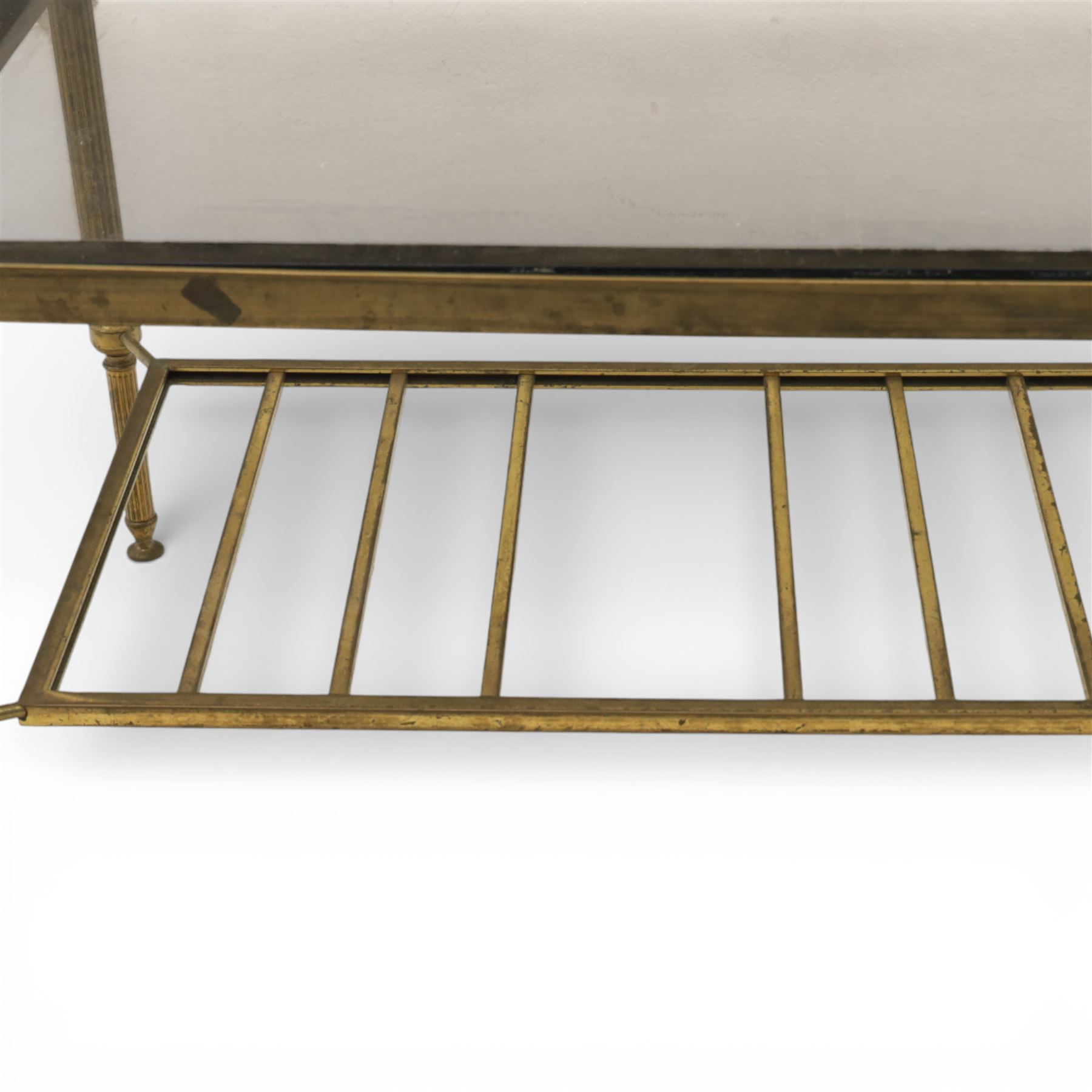 20th century brass and glass topped coffee table, the rectangular glass top within brass frame, upon four reeded legs united by lower slatted under tier 