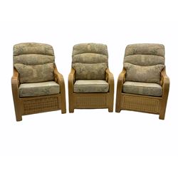 Three light wood and cane conservatory armchairs, loose beige patterned cushions