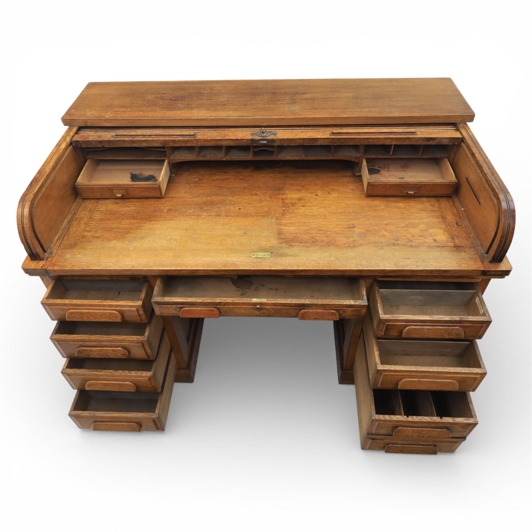 Globe Wernicke - Oak roll top desk, fitted with nine drawers, oak tambour roll top revealing a fitted interior, with single frieze drawer, flanked by four drawers to each pedestal, on a plinth base