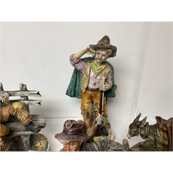 Group of Capodimonte figures, to include musical organ grinder with donkey and monkey, two tramp figures on benches, man with gun and choir boy and girl figures