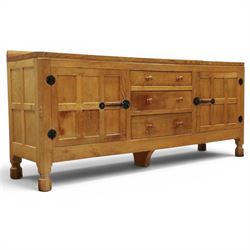 Mouseman - large adzed light oak sideboard, the rectangular top with raised galleried back, fitted with three central drawers flanked by panelled cupboards enclosing shelves, with wrought iron fittings, raised on octagonal feet, with signature carved mouse, by the workshop of Robert Thompson, Kilburn