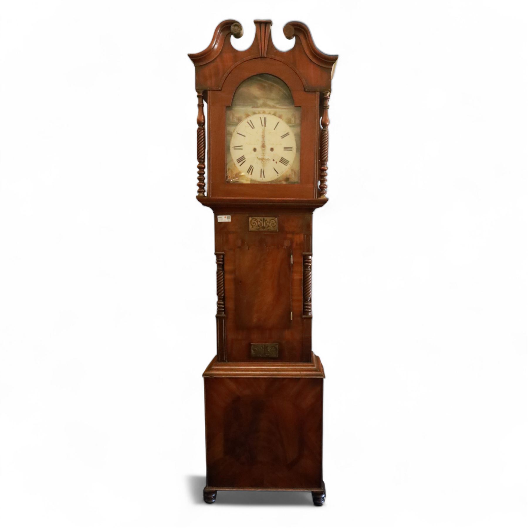 George Rutherford of Huddersfield- 8-day mahogany longcase clock c1880, with a swan neck pediment and turned patera, hood with shaped back splats and a break arch hood door flanked by ring turned pilasters, trunk with conforming recessed pilasters and a short wavy-topped trunk door, on a broad plinth raised on bracket feet, fully painted dial with matching pastoral depictions to the spandrels and break arch, with makers name, Roman numerals, subsidiary seconds and date dials and matching stamped brass hands, dial pinned via a falseplate to a rack striking movement striking the hours on a bell (bell missing). With pendulum, no weights.