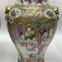 Pair of 19th century Chinese Famille Rose vases and covers, each of baluster form with twin gilt lion mask ring handles to shoulders, the flattened domed covers with gilt temple lion finials, each decorated with alternating reserves of bijin and attendants, and birds and butterflies amongst blossoming peonies, against a gilt ground profusely decorated with stylised scrolls, H32.5cm