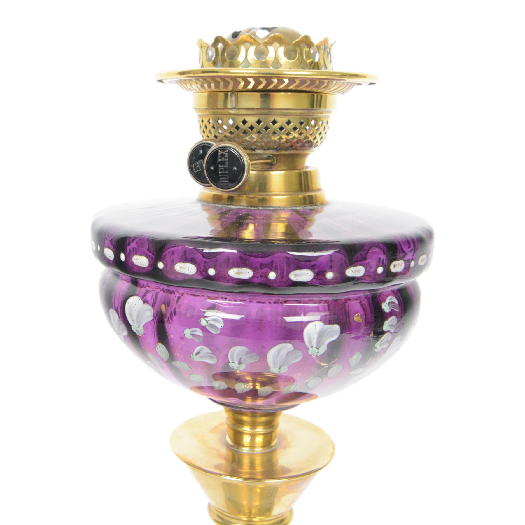 Victorian oil lamp, the brass base supporting a floral enamelled amethyst glass reservoir, duplex burner, and clear glass chimney, overall H69cm