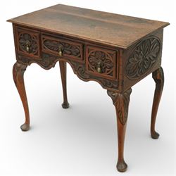 Early 20th century carved oak lowboy, rectangular moulded top above three short drawers carved with flowerhead panels and fitted with brass drop handles, shaped apron with foliate carving, raised on cabriole supports terminating in pad feet