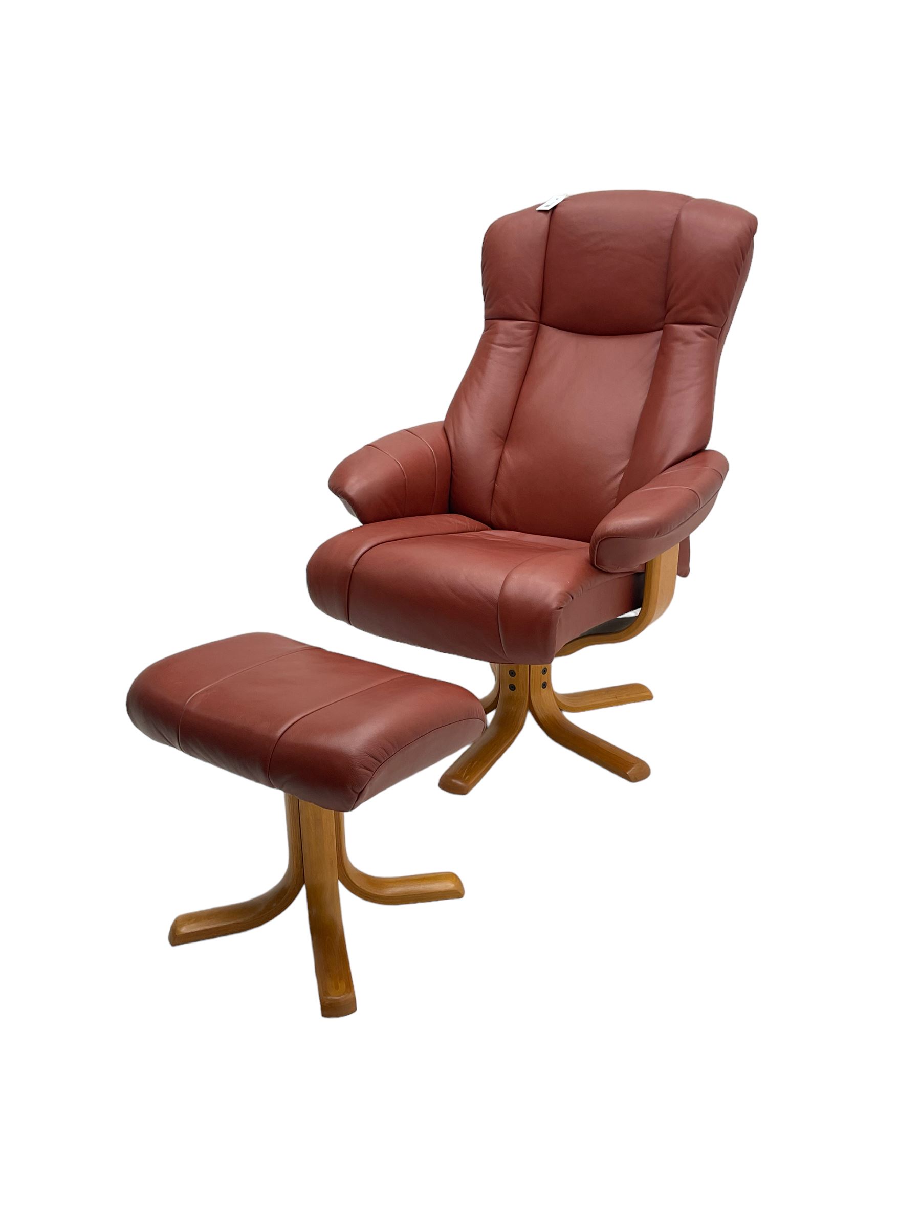 Mid-20th century design reclining armchair with swivel action, upholstered in red leather, raised on U-shaped supports with quadruform base, with matching footstool