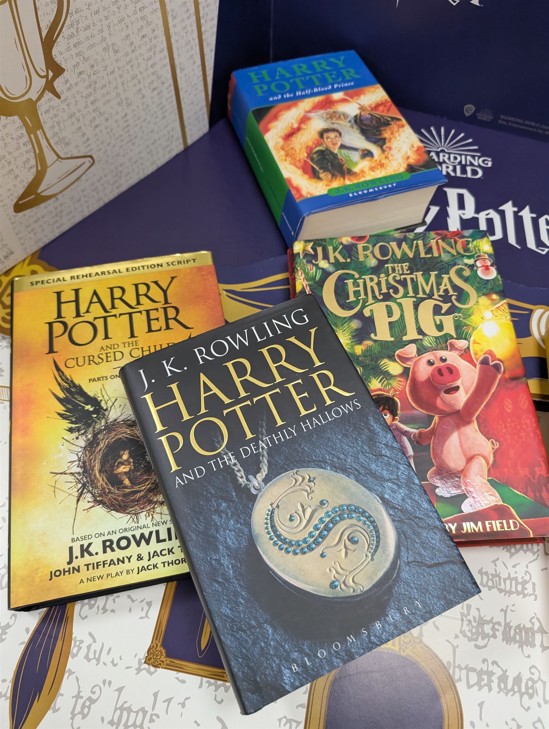 Eleven JK Rowling books, comprising six Harry Potter books, including four first editions, Fantastic Beasts screen play, Harry Potter and the Cursed Child, Tales of Beedle the Bard, Casual Vacancy first edition, Christmas Pig First edition and a Harry Potter card board back drop