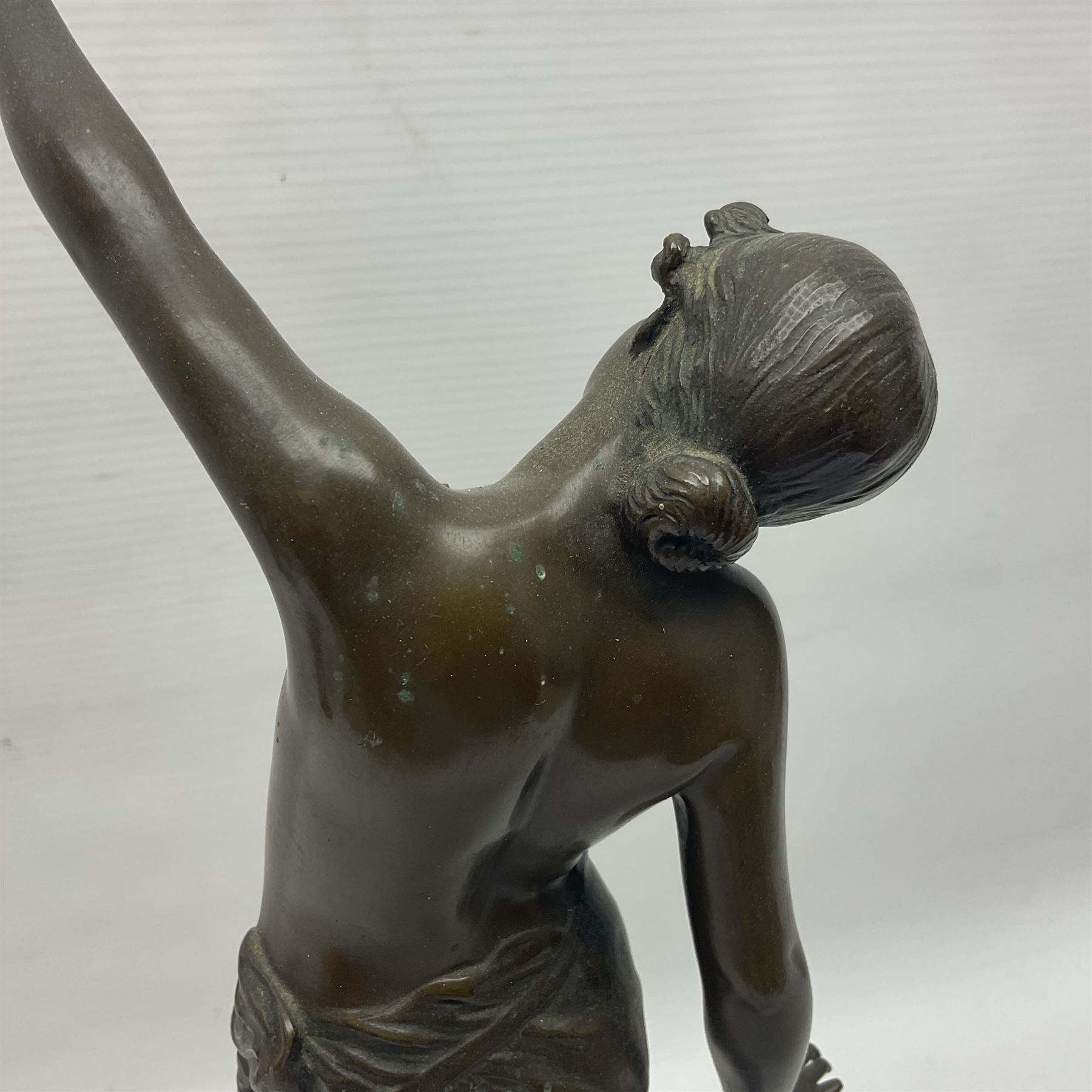 Bronzed semi nude female figure with one hand raised, upon a marble plinth, H43cm  