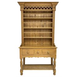 Polished pine dresser, the raised three tier plate rack with projecting cornice over fretwork frieze, the base fitted with three drawers, turned supports united by under-tier 