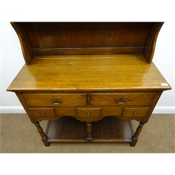  Early 20th century medium oak dresser, projecting cornice above two shelve plate rack, two long and three short drawers, turned supports joined by an undertier, W104cm, H188cm  