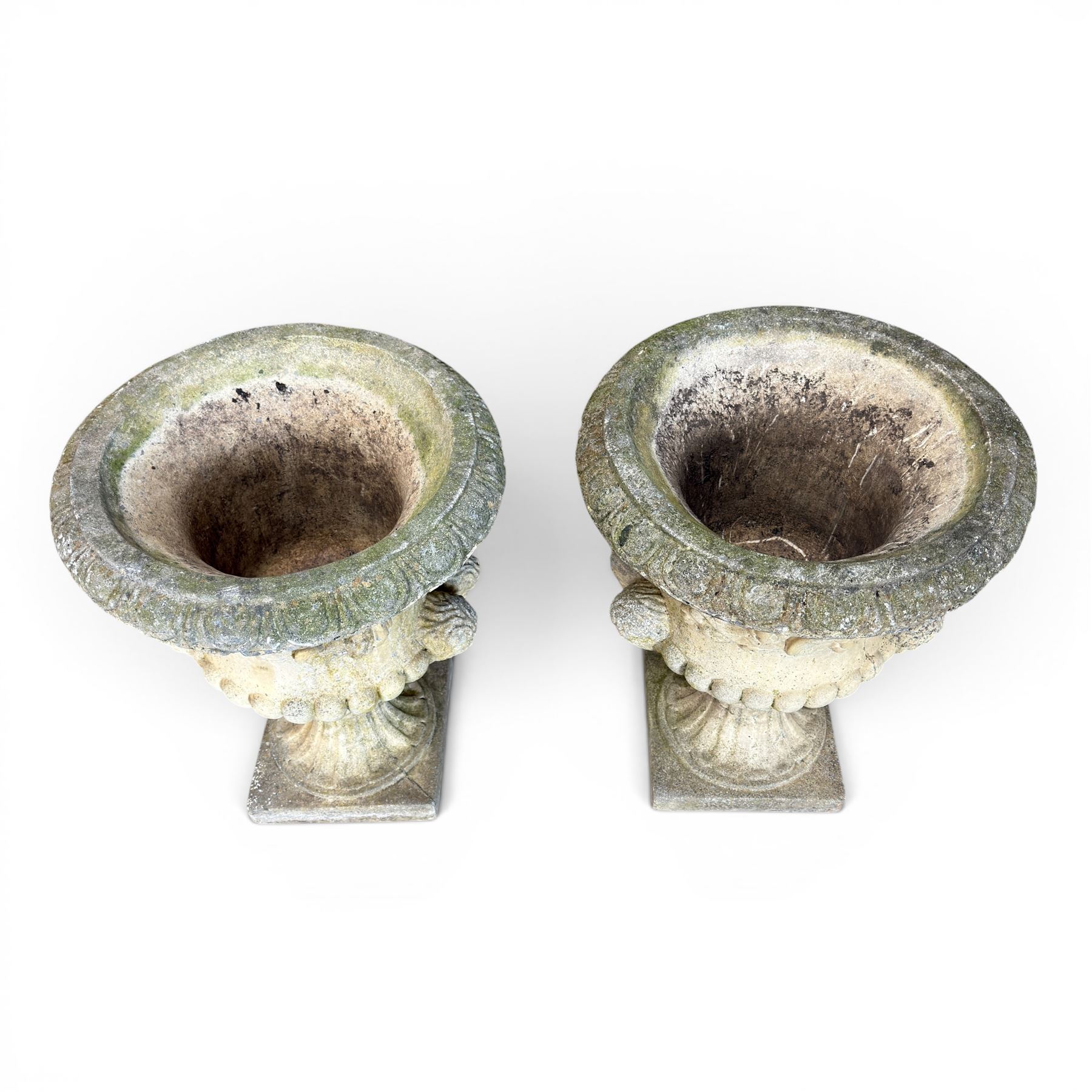 Pair of large cast stone garden urns, circular form with egg and dart border, tapering gadrooned bowl with cast handles and detail