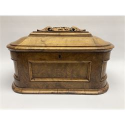 19th century figured walnut tea caddy, of rounded sarcophagus form, the hinged and slightly domed cover carved with monogramed panel flanked by acanthus leaves, opening to reveal a triple compartment interior with later mahogany lids, lifting to reveal remnants of zinc lining, H19cm L34cm D20cm
