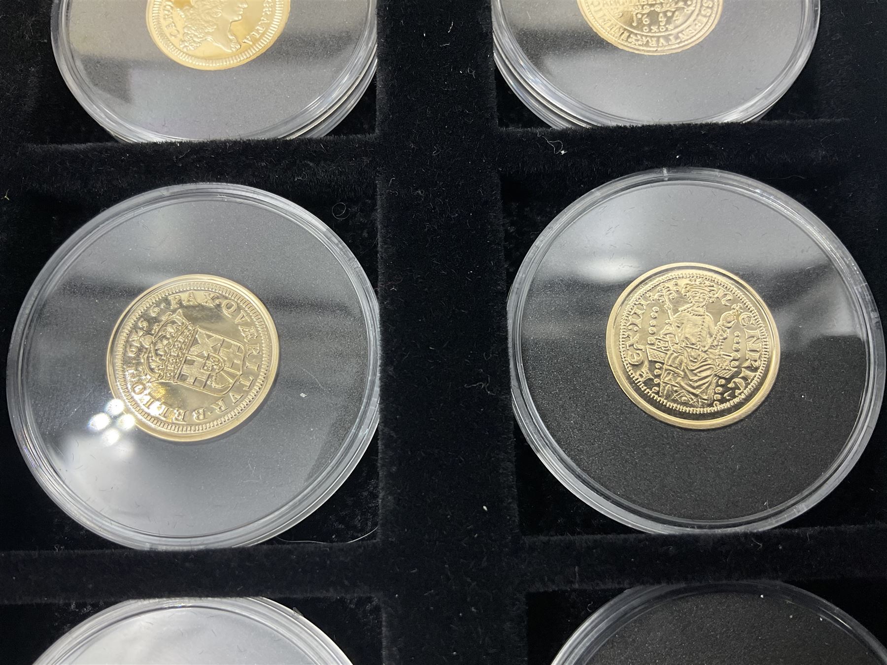 Sixteen hallmarked 9ct gold replica coins from 'The Historic Coins Of Great Britain Museum Gold Collection', housed in a Westminster display case, overall weight approximately 51.3 grams