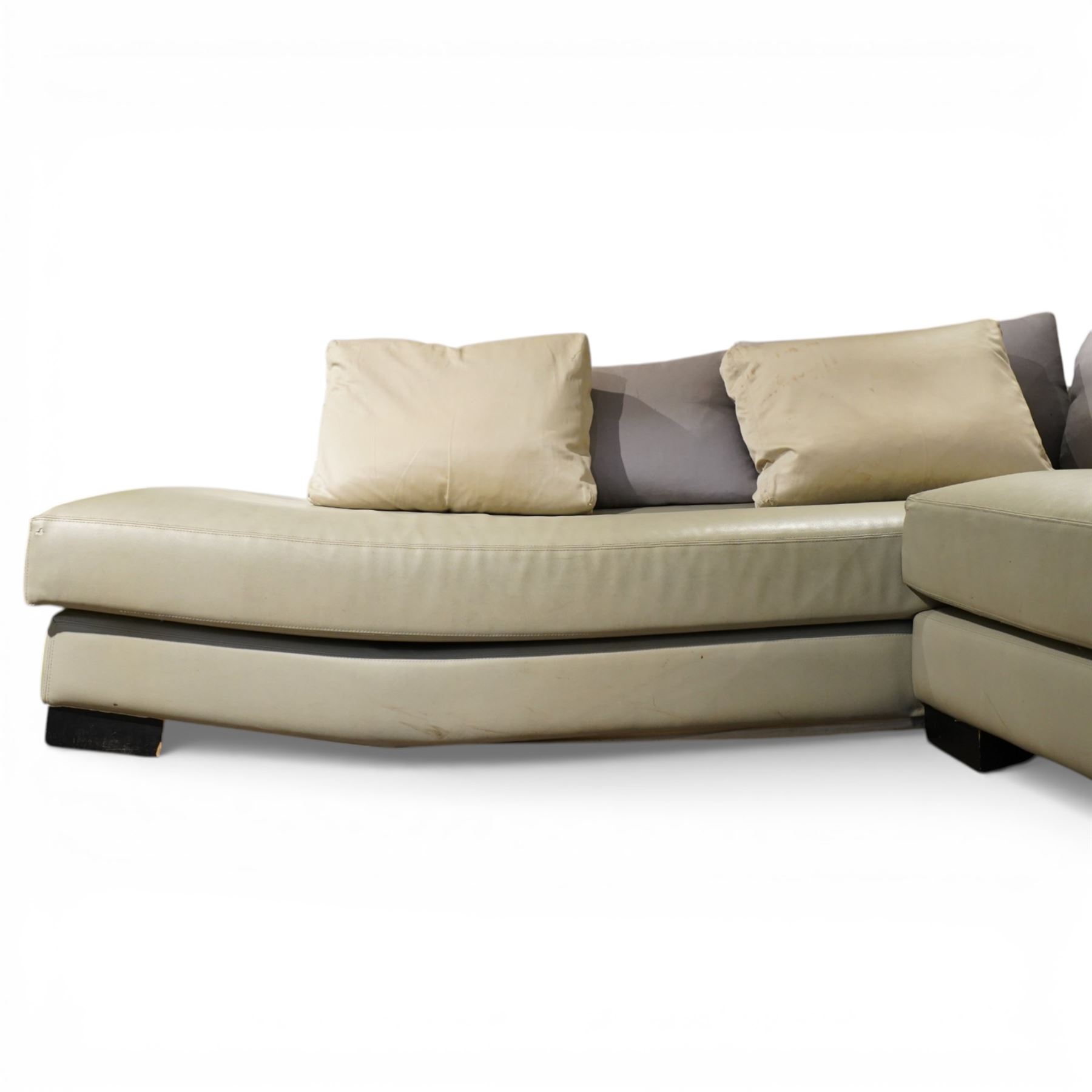 Christian Liaigre (1943-2020) - 'Arpege' handmade L-shaped sectional sofa, upholstered in neutral leather, with broad squared arms, deep seat cushions, angled chaise section, loose back cushions, raised on block feet