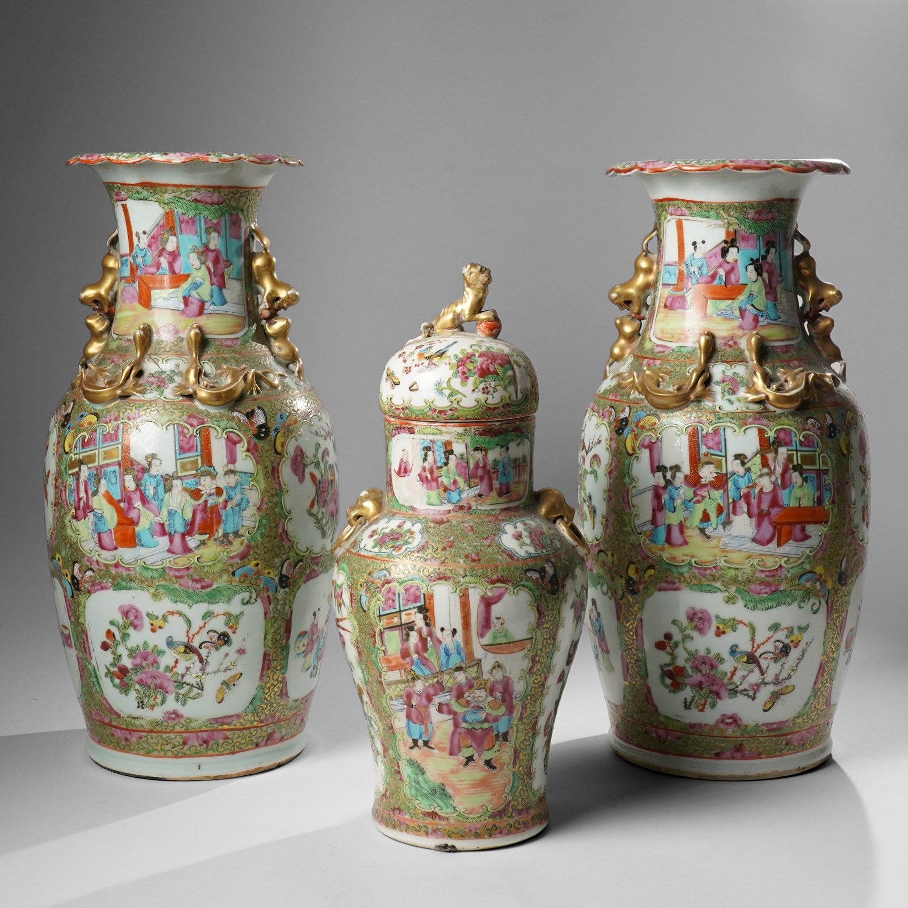 Cantonese famille rose vases, of inverted baluster form, the domed cover with gilt dog of Fu finial, H38cm; together with a further pair of Cantonese vases, each with double Buddhist lion handles and applied at the shoulders with chilong, H45cm (3)