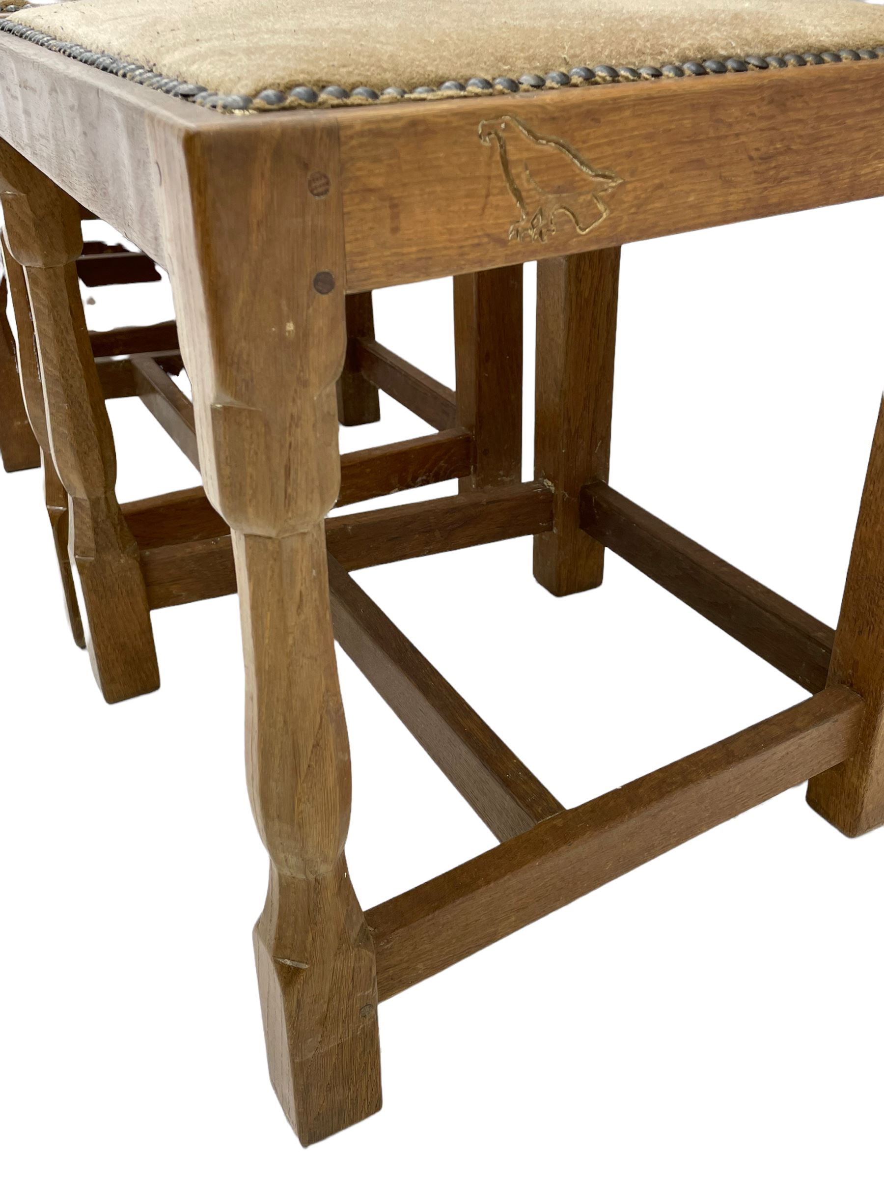 'Eagleman' set four oak dining chairs, adzed panelled backs, upholstered seats with stud work band, the side rails relief carved with inset eagle signature, shaped octagonal supports joined by stretchers, by Albert Jeffray of Sessay, Thirsk