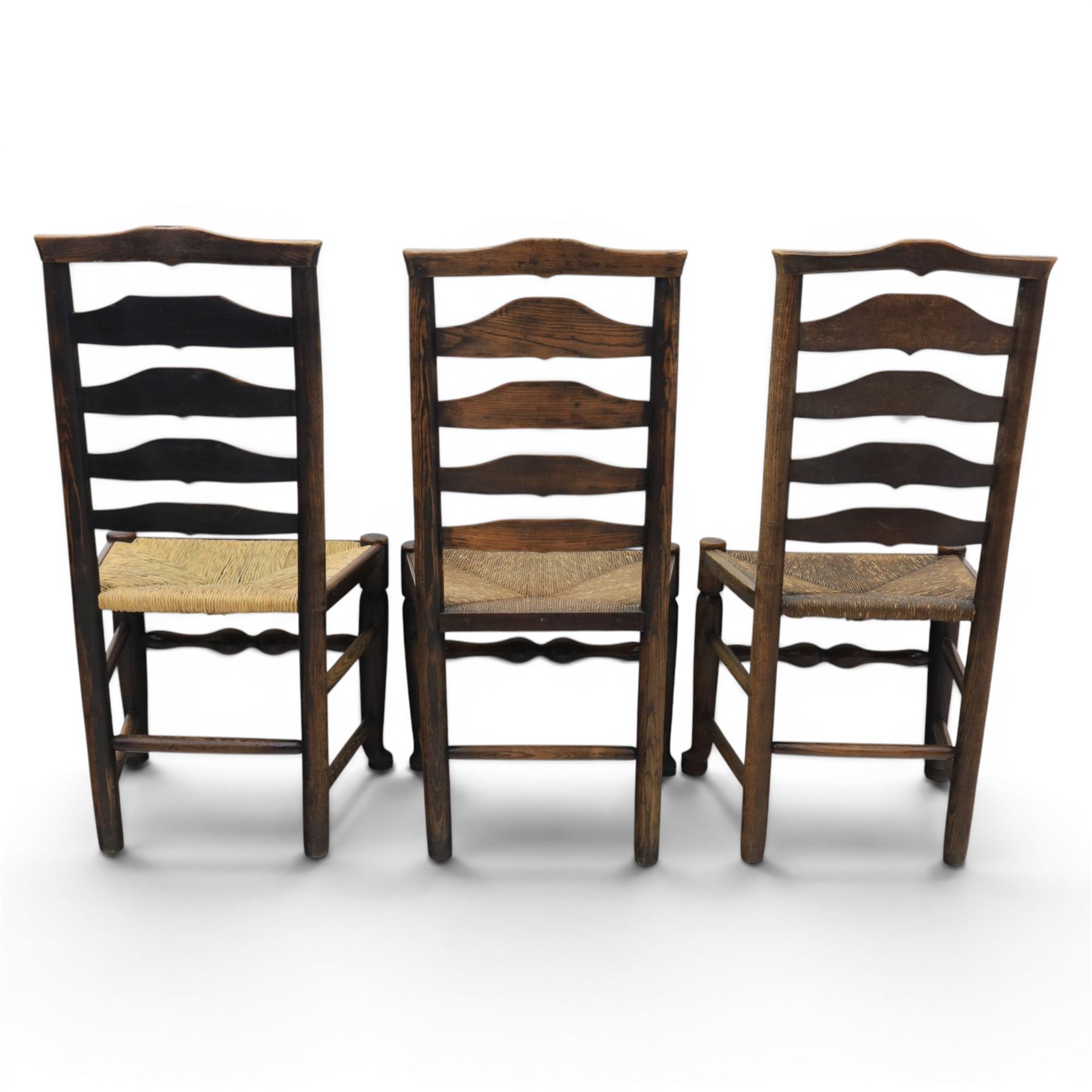 Set of seven (6+1) Georgian design country elm Lancashire dining chairs, ladder backs with rush seats, turned front leg stretcher on pad feet, height of seat 44cm, complete with fitted tie on cushions