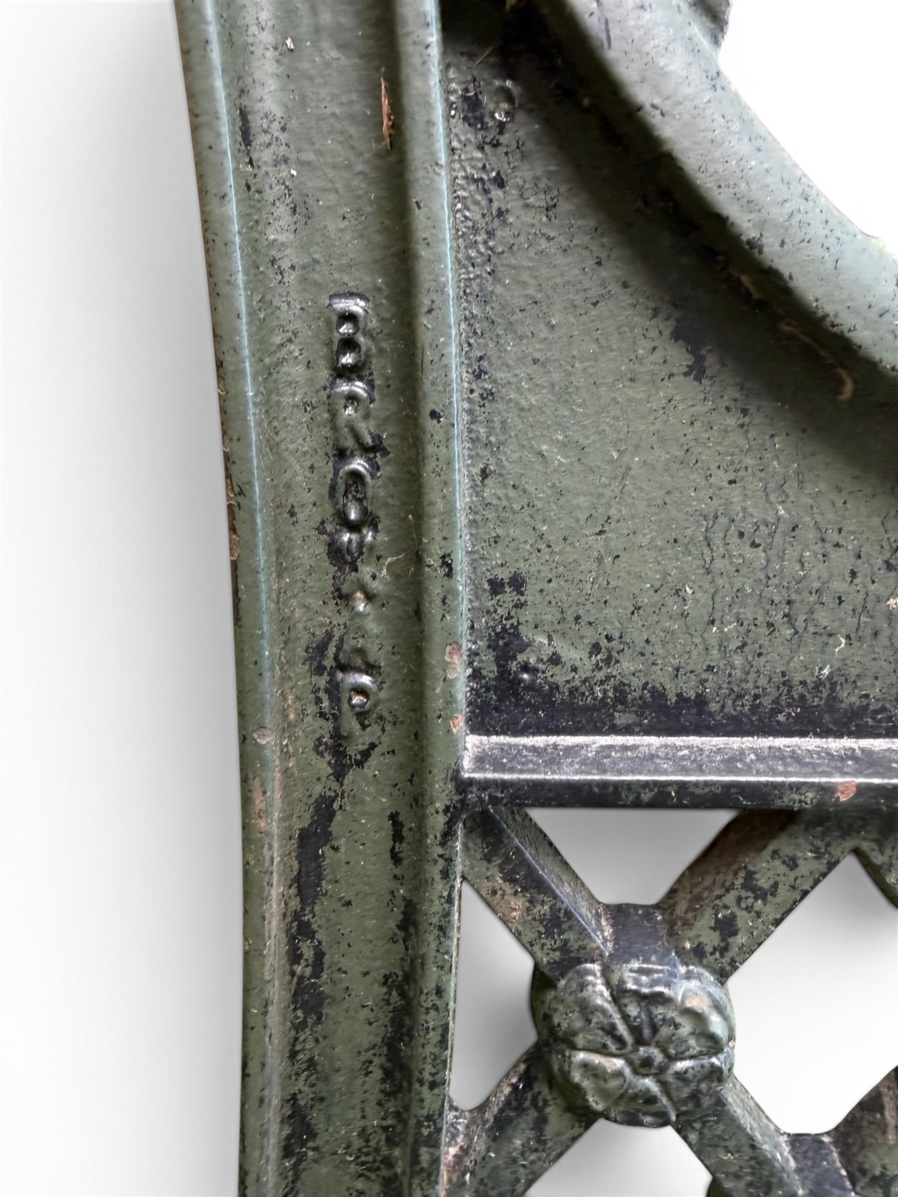 Neoclassical design cast iron and oak slatted garden bench, the twin end supports in the form of a Sphinx with acanthus carved knees and large paw feet, the pierced lattice bracket with Yorkshire rose motifs