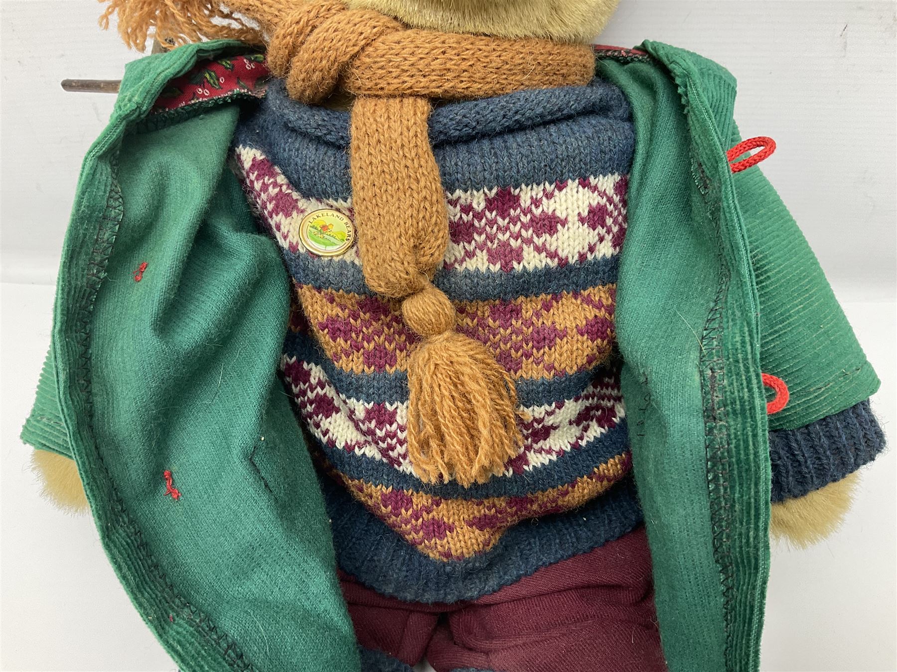 Lakeland Bears teddy bear, titled 'Walkright', dressed as a hiker in green corduroy duffle coat over fair isle jumper, trousers and knit socks, complete with leather clogs with wood soles, walkers thumb stick, knitted scarf, flat cap and rucksack housing original tag and map, H50cm