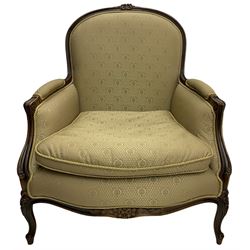 French design walnut framed armchair, arched moulded cresting rail carved with flower heads, upholstered in pale olive green with repeating pattern, scroll carved arm supports terminating to cabriole feet carved with flower heads