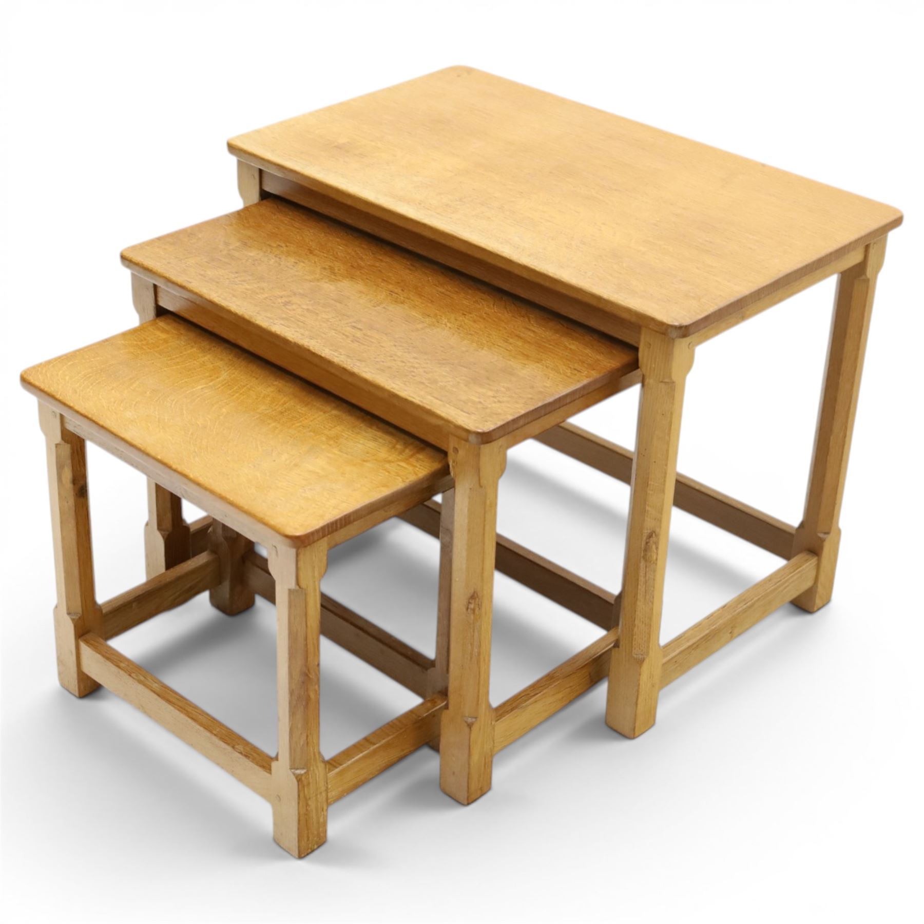 Mouseman - set of three adzed light oak nesting tables, each with rectangular top raised on octagonal legs joined by stretchers, with signature carved mouse, by the workshop of Robert Thompson, Kilburn