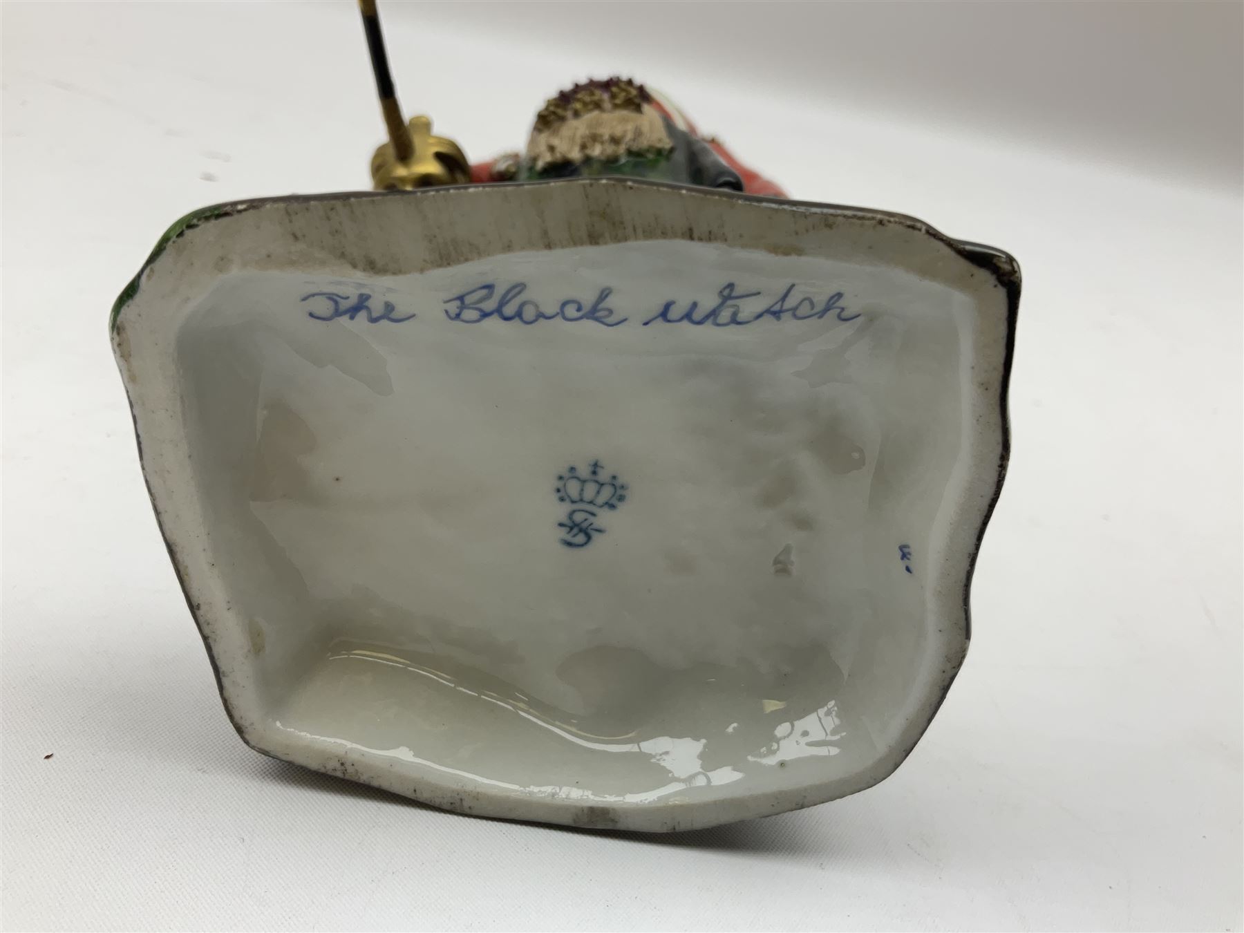 Sitzendorf figure, The Black Watch officer, c1815 standing to attention in full dress with sword, blue factory marks beneath, H28cm