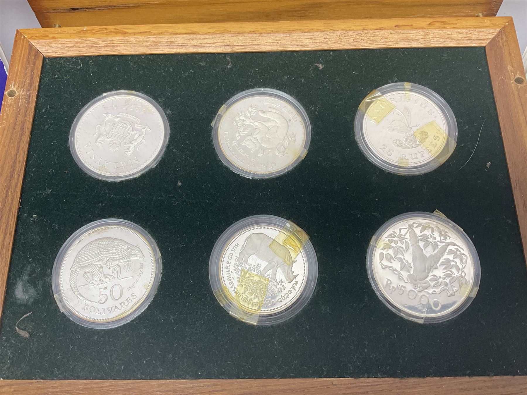 The Royal Mint 'Conservation Coin Collection' formed of twenty-four silver proof coins, housed in the wooden display case, with information booklet