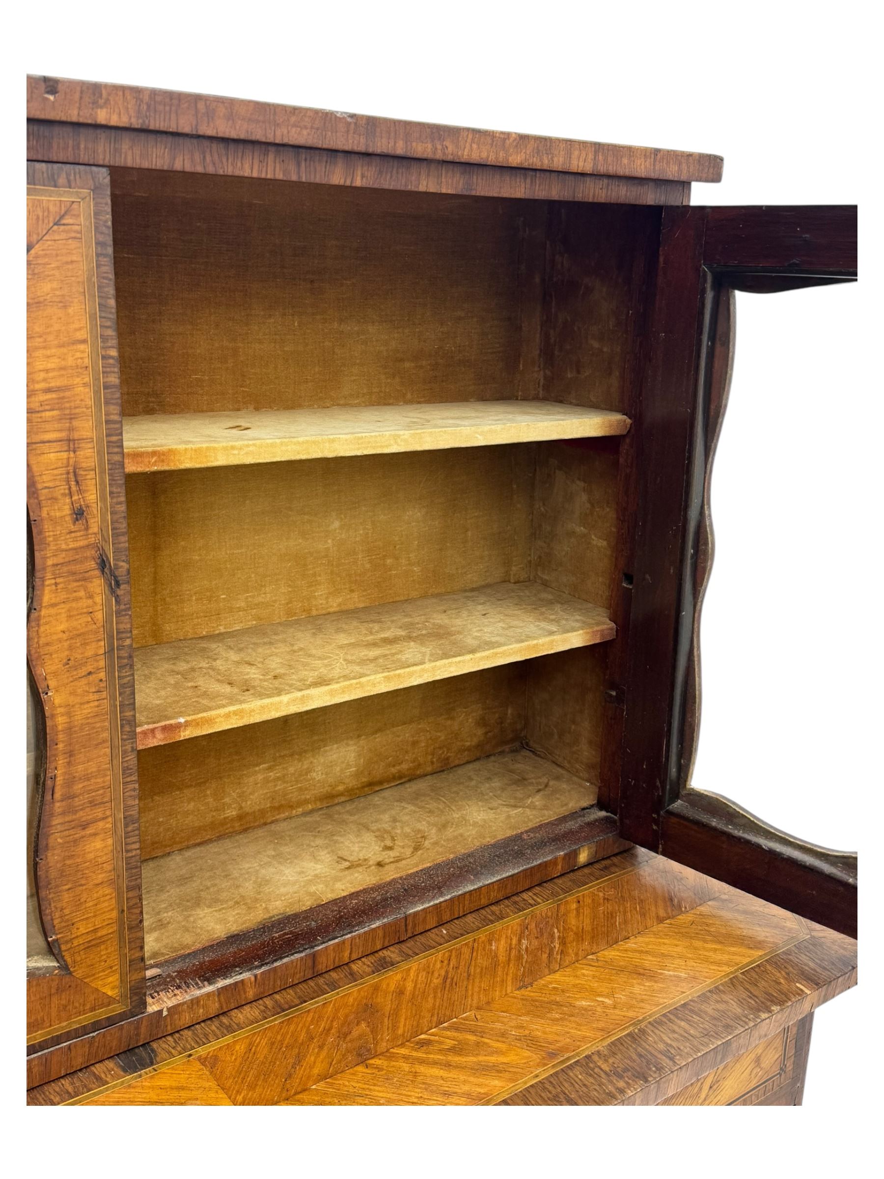 Late 19th century continental display cabinet, the upper section is glazed with twin doors with two upholster shelves, over a lower section with single draw above two glazed cupboard doors on shaped bracket feet