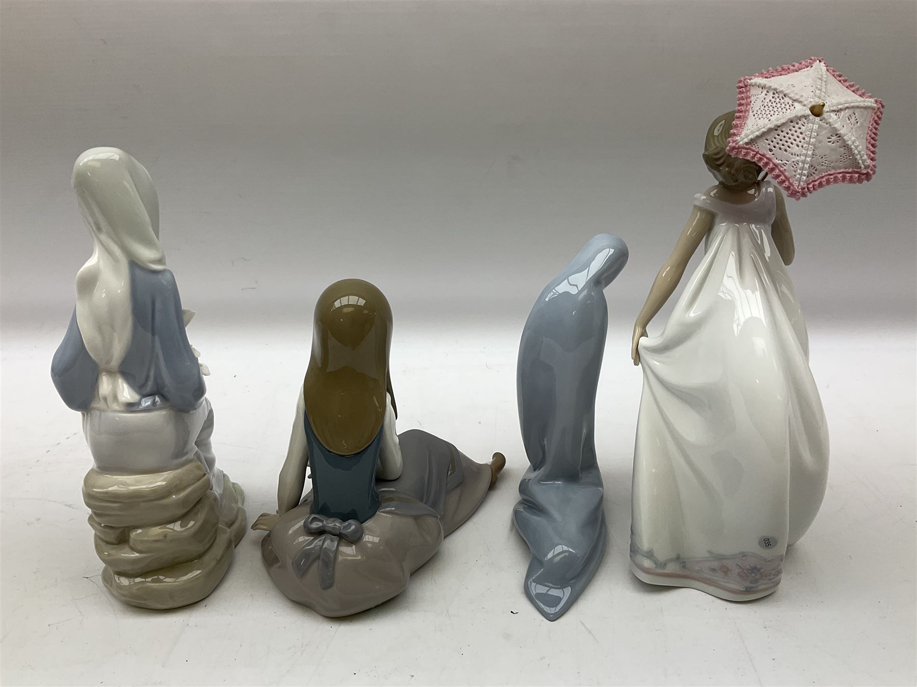Four Lladro figures, comprising Afternoon Promenade no 7636, Nostalgia no 5071, both with original boxes, Girl with Lilies no 4972 and Madonna no 4534, largest example H27cm