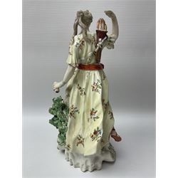 18th century Derby figure of Diana the huntress, circa 1760, modelled reaching for an arrow from quiver across her back, with recumbent hound at her feet, upon a scrolled base with bocage detail, H27.5cm